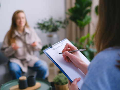 Image of a consultant taking notes during a discussion with a student about their concerns.