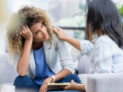 Image of a student receiving consultant support from an advisor, with the advisor putting their hand onto the student's shoulder.